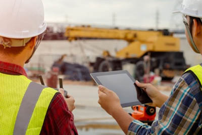 deux hommes sur un chantier avec tablette numérique