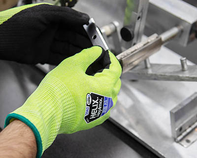mains avec gants de protection anti-coupure tenant une lame