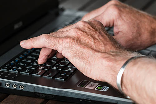 homme tapant sur son clavier d'ordinateur portable
