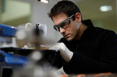 homme avec lunettes de sécurité EPI qui travail sur une machine